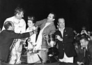 Miss Florida lächelt freundlich den händeschüttelnden Stirling Moss (links) und Gesamtsieger Umberto Maglioli zu. Links im weissen Dunlop Rennanzug ist Mike Parkes (12 Stunden von Sebring 1964)