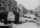 Alfred Neubauer und Juan Manuel Fangio breiten das weisse Tuch des Abschieds über den W 196 R, Hans Scherenberg nimmt die Zeremonie schmunzelnd zur Kenntniss - Abschlussfeier der Rennsaison 1955 (1955)