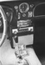 Aston Martin DB 5 Vantage (1965) - Mittelkonsole mit Uhr, Radio und Schaltern für die elektrischen Fensterheber
