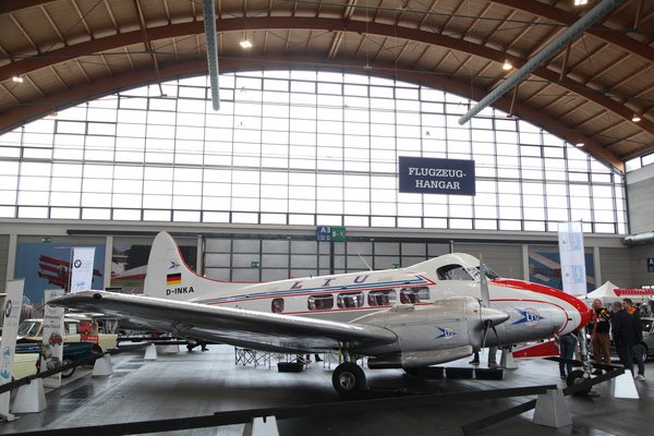 Auch Flugzeuge - prächtiger Passagierflieger (De Havilland Dove von 1949) als imposante Kulisse für die Autos - Motorworld Classics Bodensee 2019