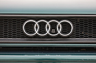 Audi Avant RS2 (1995) - der Kühlergrill ist schwarz umfahmt, die vier Ringe sind in Chrom gehalten, im dritten Ring der Zughebel für die Motorhaubenentriegelung