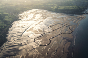 Bild Auf dem Strand der Red Wharf Bay auf der walisischen Insel Anglesey entwarf Maurice Wilks im Jahr 1947 die markante Form eines Geländewagens. Über 65 Jahre wird er mit einer ein Kilometer großen Zeichnung im Sand der geschichtsträchtigen Bucht gefeiert.