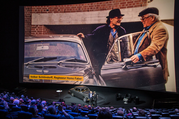 Auf der Leinwand sieht man Max Frisch (rechts) und Volker Schlöndorff mit dem Jaguar 420