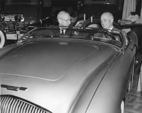 Austin Healey 100 (1952) - Leonard Lord und Donald Healey sitzen zufrieden im neuen Sportwagen an der London Motor Show 1952