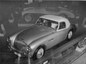 Austin Healey 100 (1954) - an der London Motor Show mit Hardtop, im Hintergrund der neue 100 S, der erst 1955 in Serie ging
