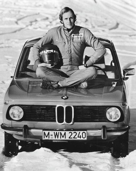 BMW 1502 (1973) - Hans-Joachim Stuck auf der Haube des kleinen BMW