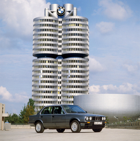BMW 325i (1988) - viertürige Limousine der Baureihe E30 vor dem BMW-"Vierzylinder"