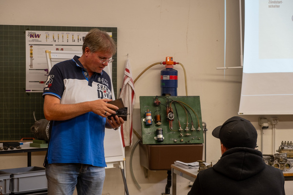 Berufsschullehrer Andreas Schranz erklährt den Lernenden die Zündanlage – 8. Autos von Dazumal 2023