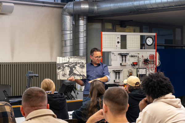 Berufsschullehrer Rolf Zahnd mit einem Bild der früheren Werkhalle – 8. Autos von Dazumal 2023