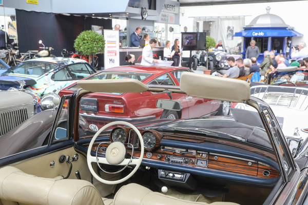 Blick auf die Auktion durch die Windschutzscheibe des Mercedes-Benz 220 SE Cabriolets - Versteigerung der Oldtimer Galerie Toffen am 14. Oktober 2023