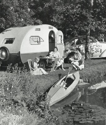 Campingidyll am Fluss - Familienurlaub von Sportberger-Gründer Hans Berger. Der Wohnwagen "Karawane" wird von Bergers Adler 2,5 Liter gezogen. Das Sportberger Faltboot ist auch dabei