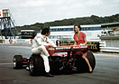 Image: Carlos Pace chats with a friend, sitting on the rear tires of his 1976 Brabham-Alfa Romeo BT45