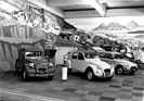 Citroën 2 CV (1976) - attraktiver Standaufbau mit Rallye-Autos im Hintergrund - Genfer Autosalon 1976