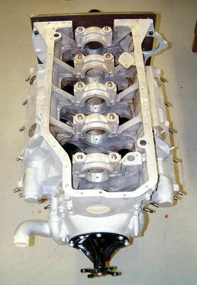 Blick von vorn auf das Kurbelgehäuse des V8 mit installierter Wasserpumpe und massiven Hauptlagerdeckeln.