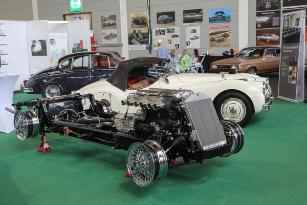Das unverkleidete Chassis eines Jaguar XK, dahinter der vollständige Wagen auf dem Jaguar-Clubstand - Klassikwelt Bodensee 2023