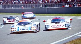 Dauer 962 LM (1994) – Aussen in einer Le-Mans-Kurve hat ein Dauer-Porsche das schlankere Frontprofil als der Porsche-betriebene Courage, den er überholt Dauer 962 LM (1994) – Aussen in einer Le-Mans-Kurve hat ein Dauer-Porsche das schlankere Frontprofil als der Porsche-betriebene Courage, den er überholt
