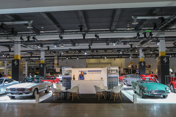 Der Stand der Touring Garage mit Katrin Rau hinter dem Tresen - Auto Zürich 2022