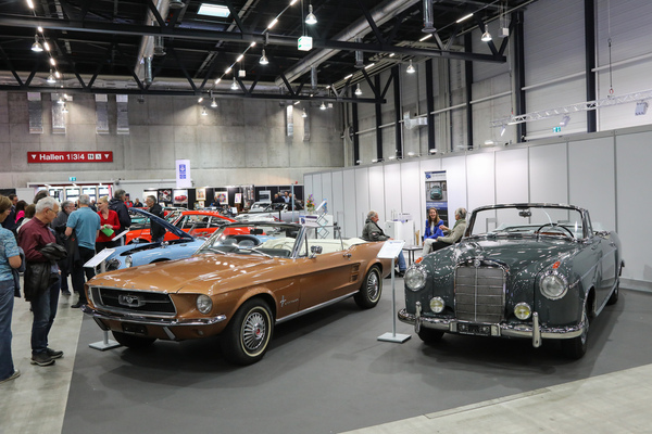 Der Stand der Touring Garage mit einem Mercedes-Benz 220 Cabriolet und einem Ford Mustang Cabriolet - Swiss Classic World Luzern 2024