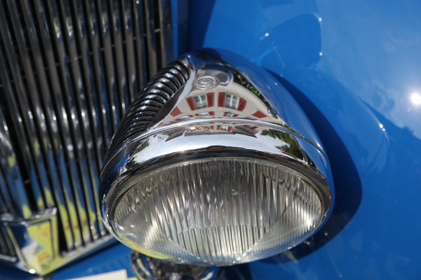 Die Dorfarchitektur spiegelt sich im Scheinwerfer des Triumph - Oldtimer in Obwalden (O-iO) 2018