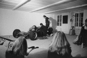 Die Lotus-Climax von Jim Clark im «Salon» von Jean Tinguely in Neyruz 1972-73 - Jean Tinguely, die beiden Mechaniker von Jo Siffert, Walo Schibler und Jean-Pierre Oberson, und Freundinnen