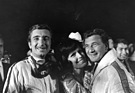 Die Schönheitskönigin freut sich mit den beiden Siegern Jo Siffert (links) und Hans Herrmann. (12 Stunden von Sebring 1968)