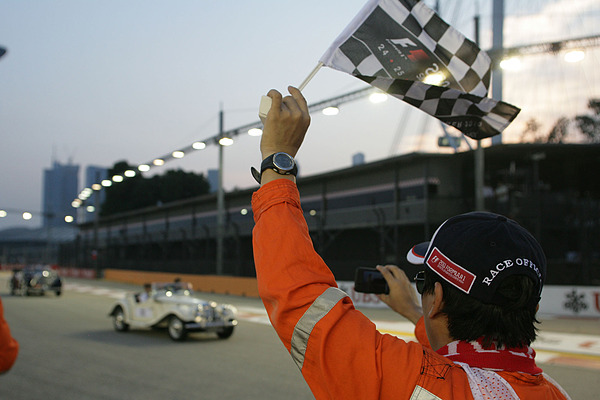 Die Streckenposten winken und filmen gleichzeitig das Geschehen.