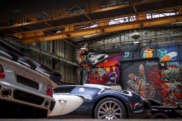 Image: A colorful graffiti artwork forms the background of the super sports car area - National Automobile Museum