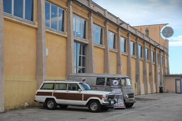 Ein früher Jeep Cherokee und ein Mercedes Benz L 319 von 1960 vor einer Halle - Auto e Moto d'Epoca 2014