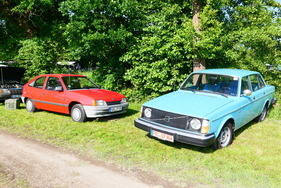 Ein hellblauer Volvo der Serie 240 beschnuppert sich mit einem roten Opel Kadett E mit LS-Ausstattung. – Bockhorner Oldtimermarkt 2025