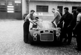 Enzo Ferrari mit dem 125 S im Innenhof der Fabrik (1947) Enzo Ferrari mit dem 125 S im Innenhof der Fabrik (1947)