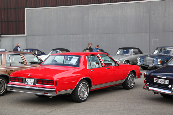 Es darf auch einmal etwas farbiger sein - rote US-Limousine zwischen mehr oder weniger grauen Europäern auf dem privaten Fahrzeugmarkt - Swiss Classic World Luzern 2021