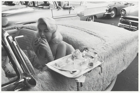 Essen im Drive-Through im Pelz-Auto - gezeigt in der Fotoausstellung “Das Auto - Eine Liebesgeschichte” in der Fabrik der Künste