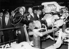 Der Schweizer Bundespräsident Paul Chadet inspiziert Chassis und Motor des neuen Fiat am Genfer Automobilsalon 1959.