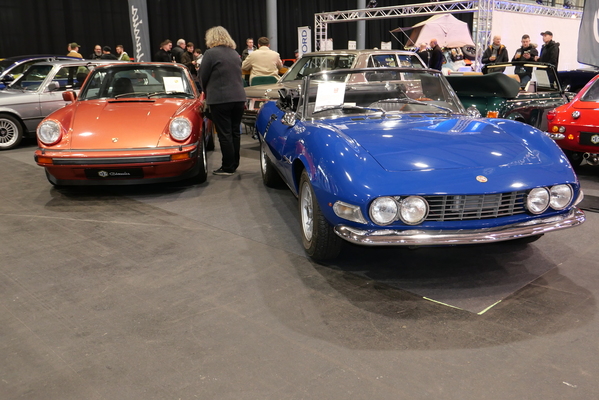 Fiat Dino 2000 Spider von 1968 für 114'900 Euro; daneben ein Porsche 911 Carrera 3.0 Targa von 1977 in Sienarot-Metallic für 75'900 Euro – Bremen Classic Motorshow 2025