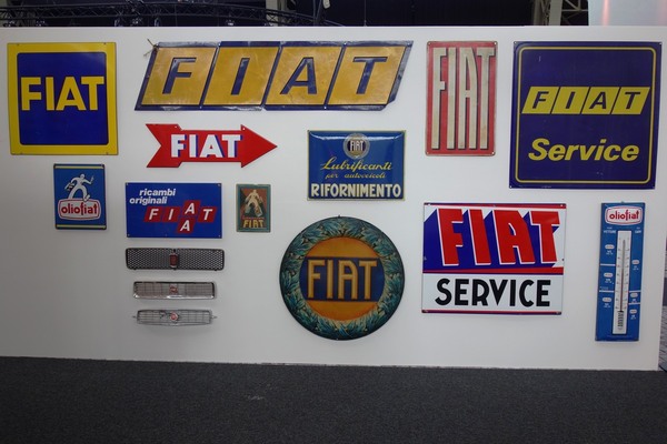 Fiat-Schriftzüge in Blech: mal als Emailleschild, mal im Kühlergrill – Ausstellung "125 Jahre Fiat" in der Autoworld Brüssel