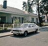 Spiessigkeit und Sportlichkeit: ein Capri 1700 GT XLR mit Rallye-Lackierung vor einem Bungalow 1972