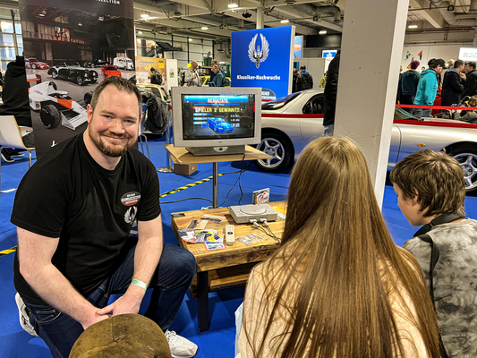 Gasgeber an der historischen Gaming-Konsole: Motor Klassik-Redakteur Daniel Endress, selbst Fan exotischer US-Oldies, mit spielfreudigen Standbesuchern.
