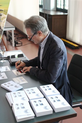 Image: Designer Vito Noto signs his work - launch of the four Swiss stamps at the Emil Frey Classic Center