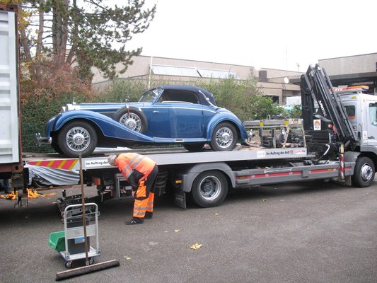 Bild Grossauftrag für Kienle - wegen des extrem langen Radstands muss auch das Mercedes-Benz 540 K Cabriolet A von 1937 aus dem Container zunächst auf einen Autotransporter mit absenkbarer Laderampe geschoben werden, um anschließend vorsichtig herunter manövriert werden zu können