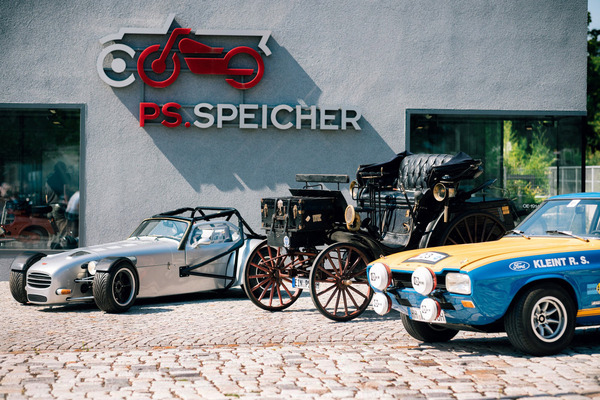 Bild Gruppenbild mit Dame – Der flache Donkervoort und Walter Röhrls Ford Capri RS nehmen die Benz Victoria vor dem Kassenhaus des PS.SPEICHER charmant in ihre Mitte