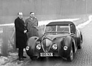 Healey 2.4 Litre (1947) - James Watt, der kaufmännische Direktor der Healey-Werke zeigt den Sportwagen bei widrigen Wetterbedingungen