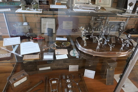 Im Erdgeschoss befinden sich zahlreiche Vitrinen mit Erinnerungsstücken: Modelle, Kühlerfiguren, persönliche Gegenstände wie ein französischer Führerschein des früheren Rolls-Royce-Geschäftsführers Ernest Hives. In der Mitte links die "Mitzi Trophy of Disgrace"