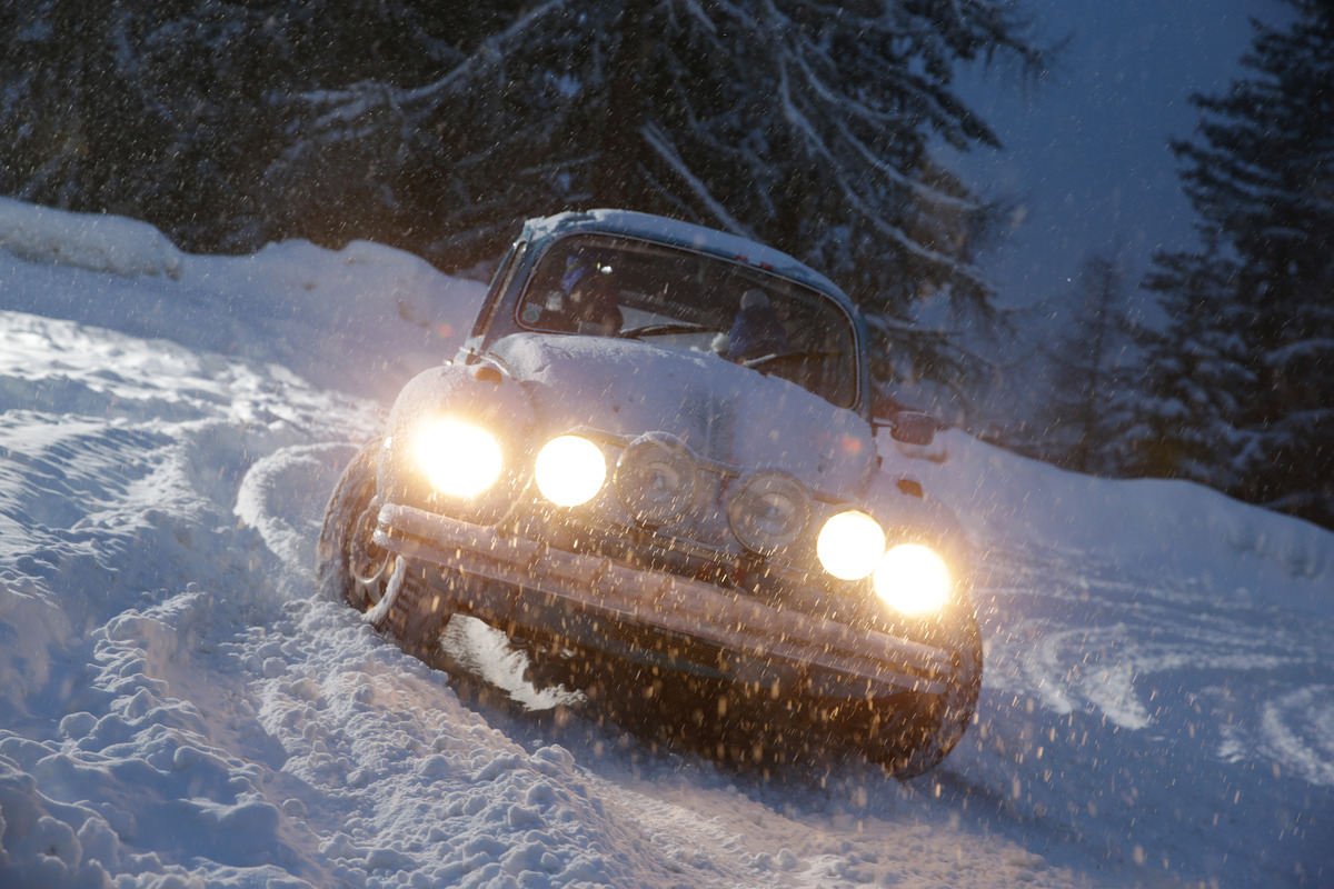 Ein Oldtimer kämpft sich bei nächtlicher Dunkelheit durch den Schnee