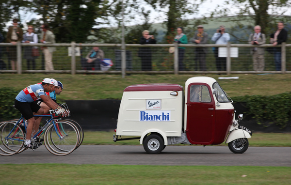 Bild: Impressionen vom Goodwood Revival 2013 - Fahrradrennfahrer mit originalen Begleitfahrzeugen