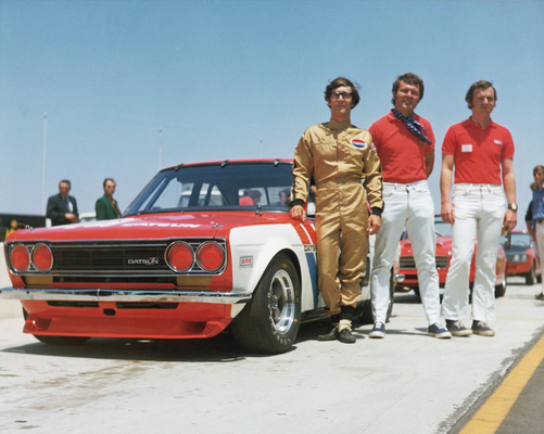 Impressionen von «The Mitty» 2018 - John Morton im goldigen Rennoverall neben ihrem Datsun 510