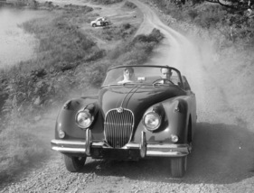 Jaguar XK 150 Drophead Coupé (1960) - auf einer staubigen Strasse Jaguar XK 150 Drophead Coupé (1960) - auf einer staubigen Strasse