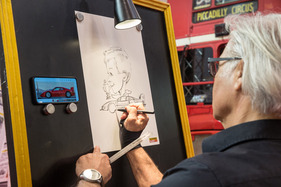 Karikatur für einen guten Zweck: Stamm-Illustrator Lothar Krebs am Stand von Oldtimer Markt – Techno Classica 2024