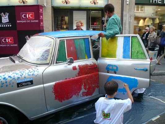 Kinder bemalen einen Mercedes-Benz 220 (Heckflosse) von 1961 zwecks Geldsammelns für die Kinderkrebshilfe Schweiz