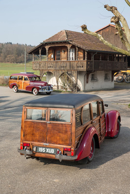 Lea-Francis 14 HP Estate Car (1951) - zwei Woodies vor einem Holzhaus - im Hintergrund ein Chevrolet Fleetmaster von 1948