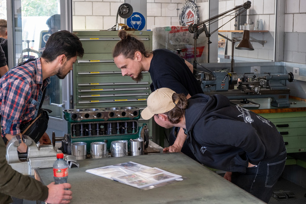 Lernende inspizieren neugierig einen Zylinderkopf – 8. Autos von Dazumal 2023